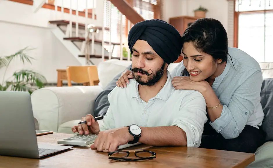 A photo showing a couple sitting at a table with a laptop, discussing their financial goals.