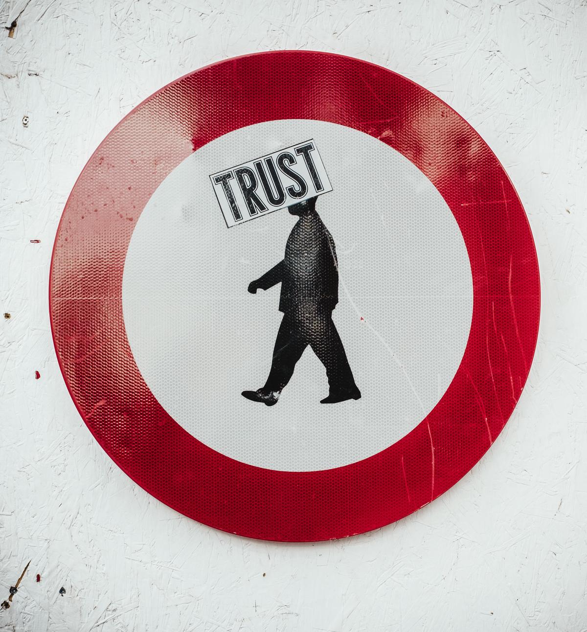 Image of an individual sitting alone, surrounded by broken trust symbols and trying to mend them